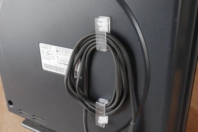 セリアの透明 配線コードフック2P粘着を家電に設置した様子