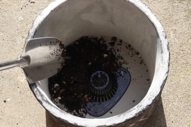 ダイソーの鉢底ネット（7.1cm×7.5cm×4.5cm、6個組）を鉢にセットして土を入れる様子