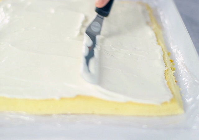 オレンジロールケーキ　レシピ　ケーキの端を斜めに切り落としチーズクリームを塗る