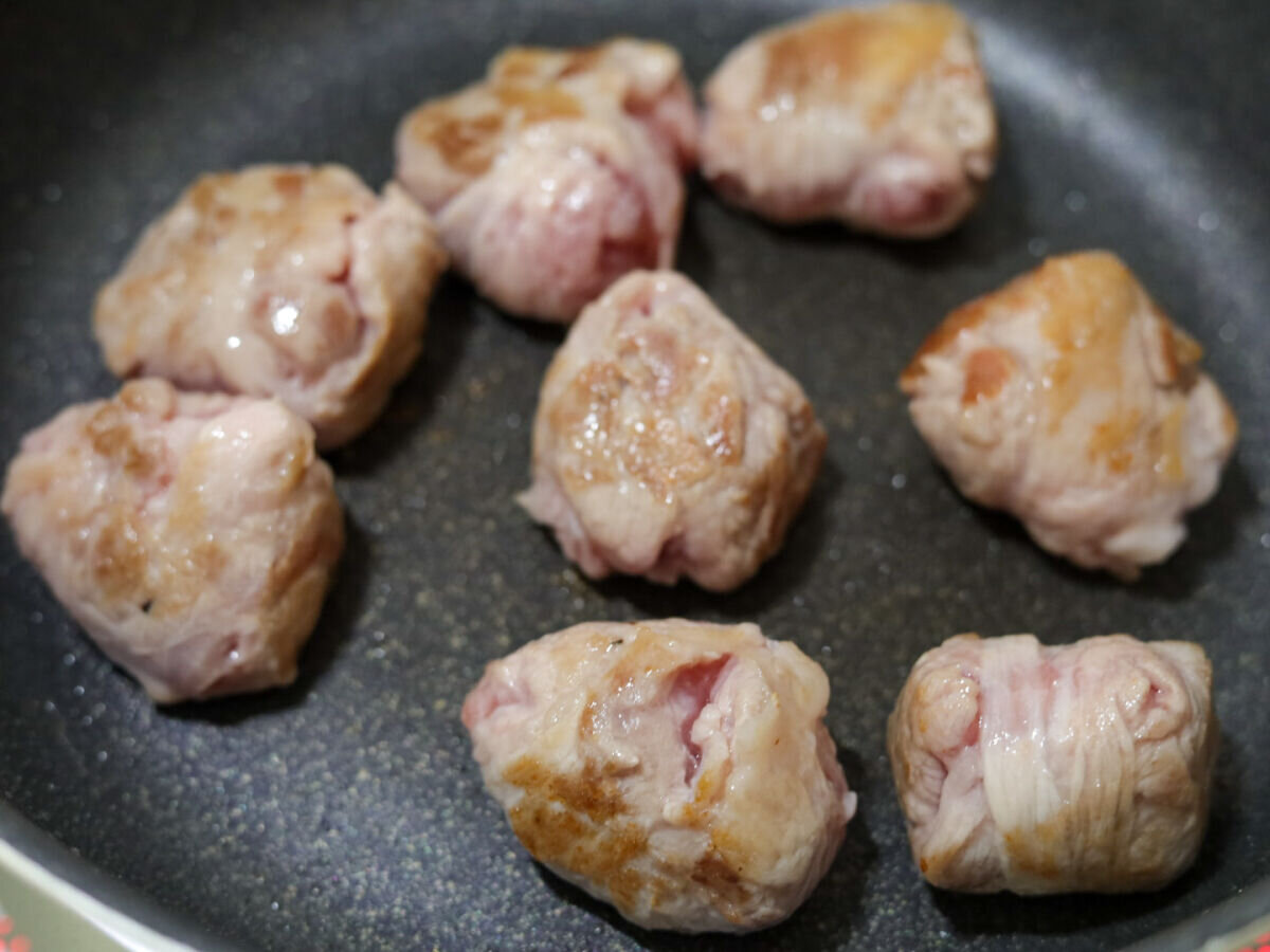 フライパンで焼かれ、全体にこんがり焼き色がついた豚こまボール フライパンで焼かれ、全体にこんがり焼き色がついた豚こまボール