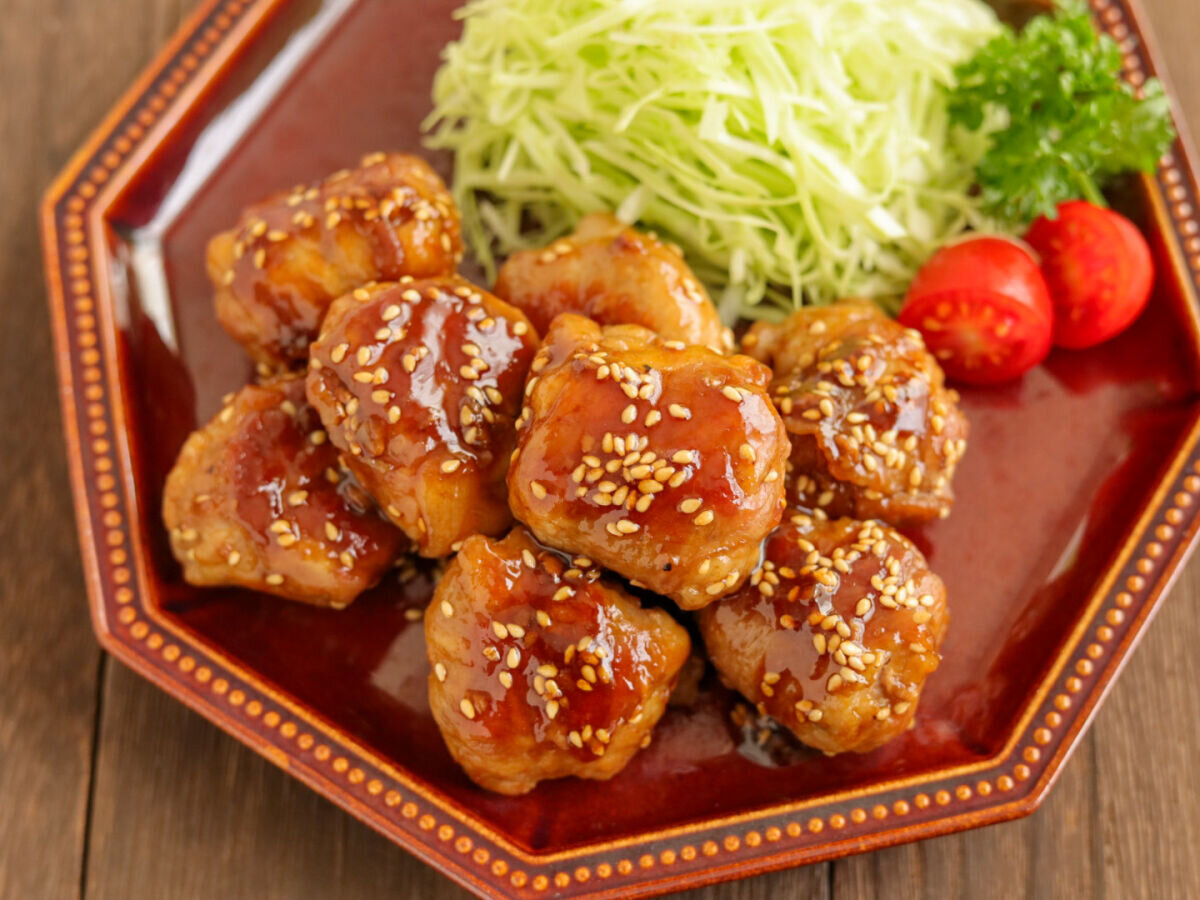 茶色い八角形の皿に盛り付けられた、豚こまボールの照り焼きと付け合わせの俯瞰 茶色い八角形の皿に盛り付けられた、豚こまボールの照り焼きと付け合わせの俯瞰