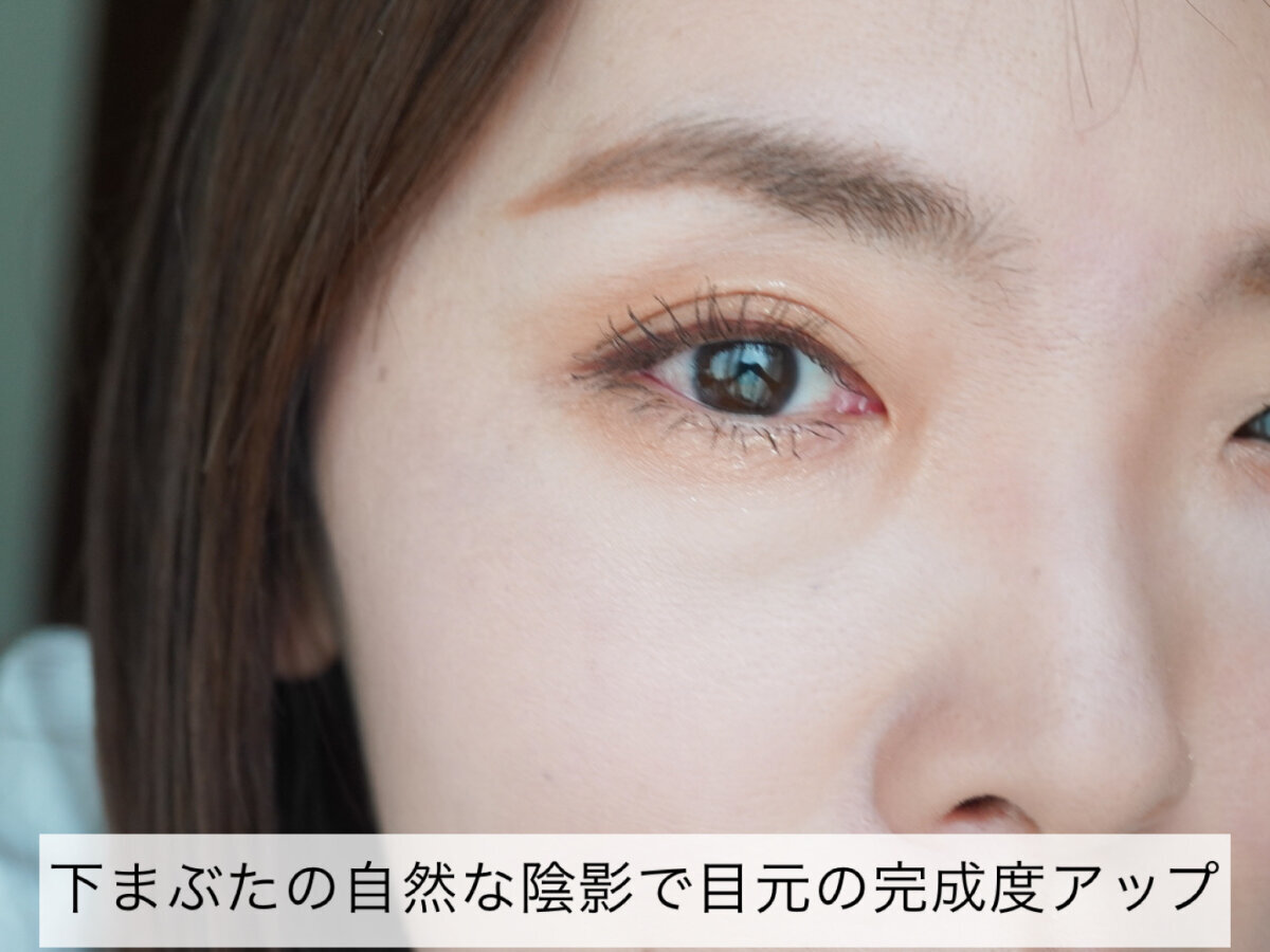 女性の顔のアップ。目元にメイクが施され、下まぶたにも淡いアイシャドウが塗られている。 女性の顔のアップ。目元にメイクが施され、下まぶたにも淡いアイシャドウが塗られている。
