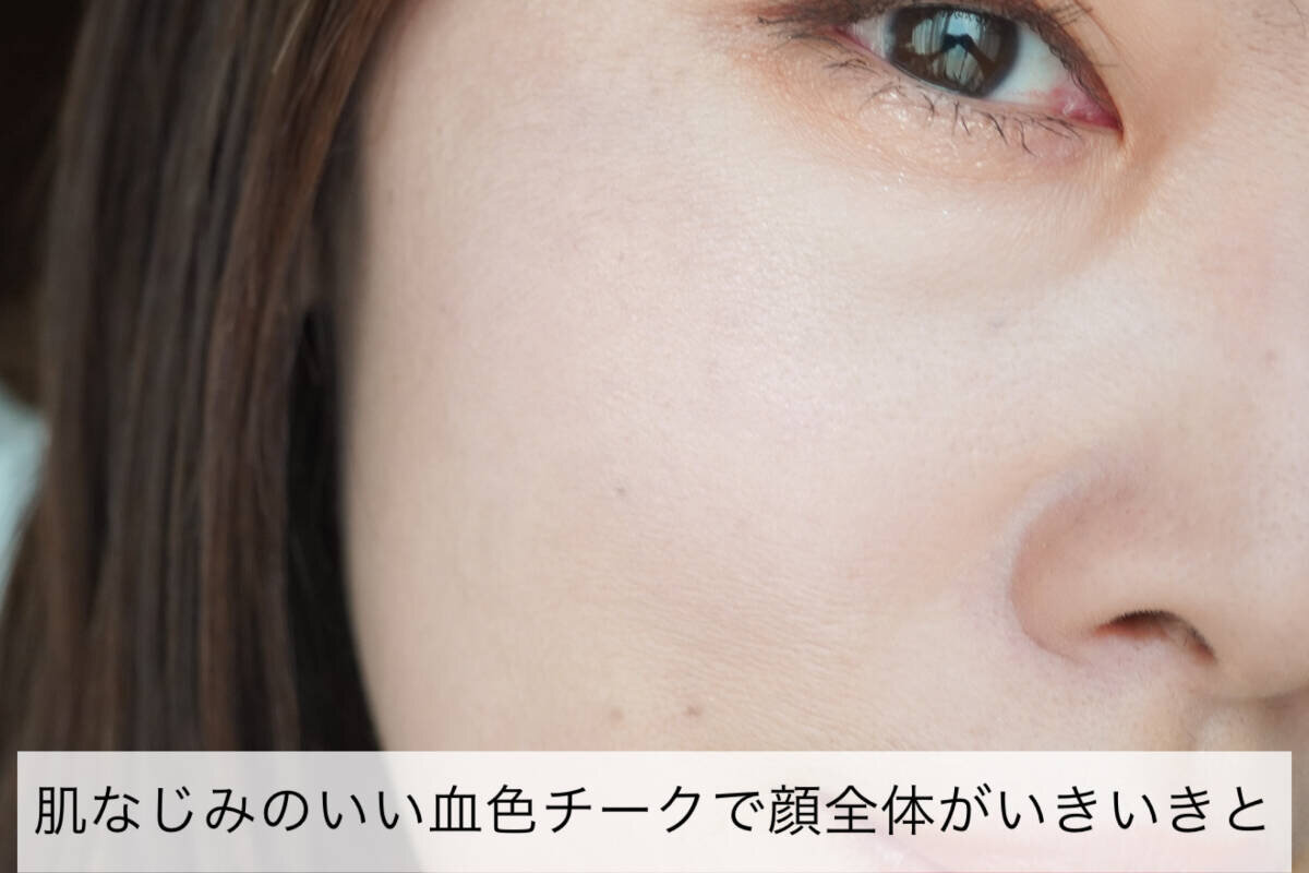 女性の顔のアップ。頬にピンク系のチークがほんのり塗られ、血色感がプラスされている。 女性の顔のアップ。頬にピンク系のチークがほんのり塗られ、血色感がプラスされている。