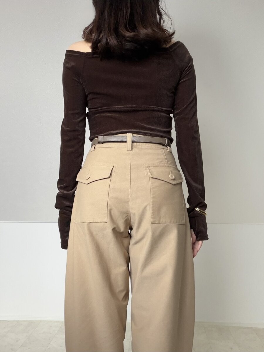 ベージュのバレルレッグパンツとブラウンのベルベットトップスを着た女性の後ろ向き全身