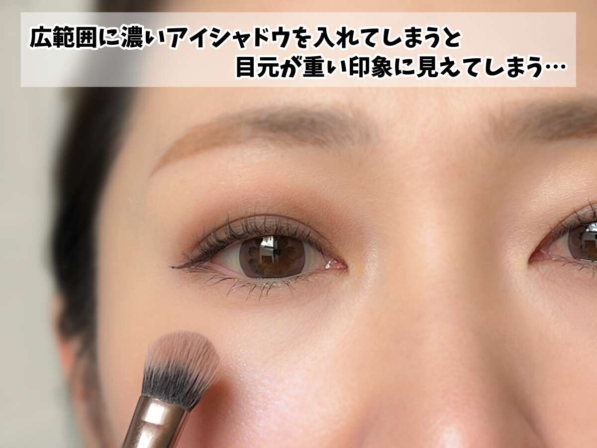 女性がアイシャドウブラシでまぶたに濃いアイシャドウを広げている様子