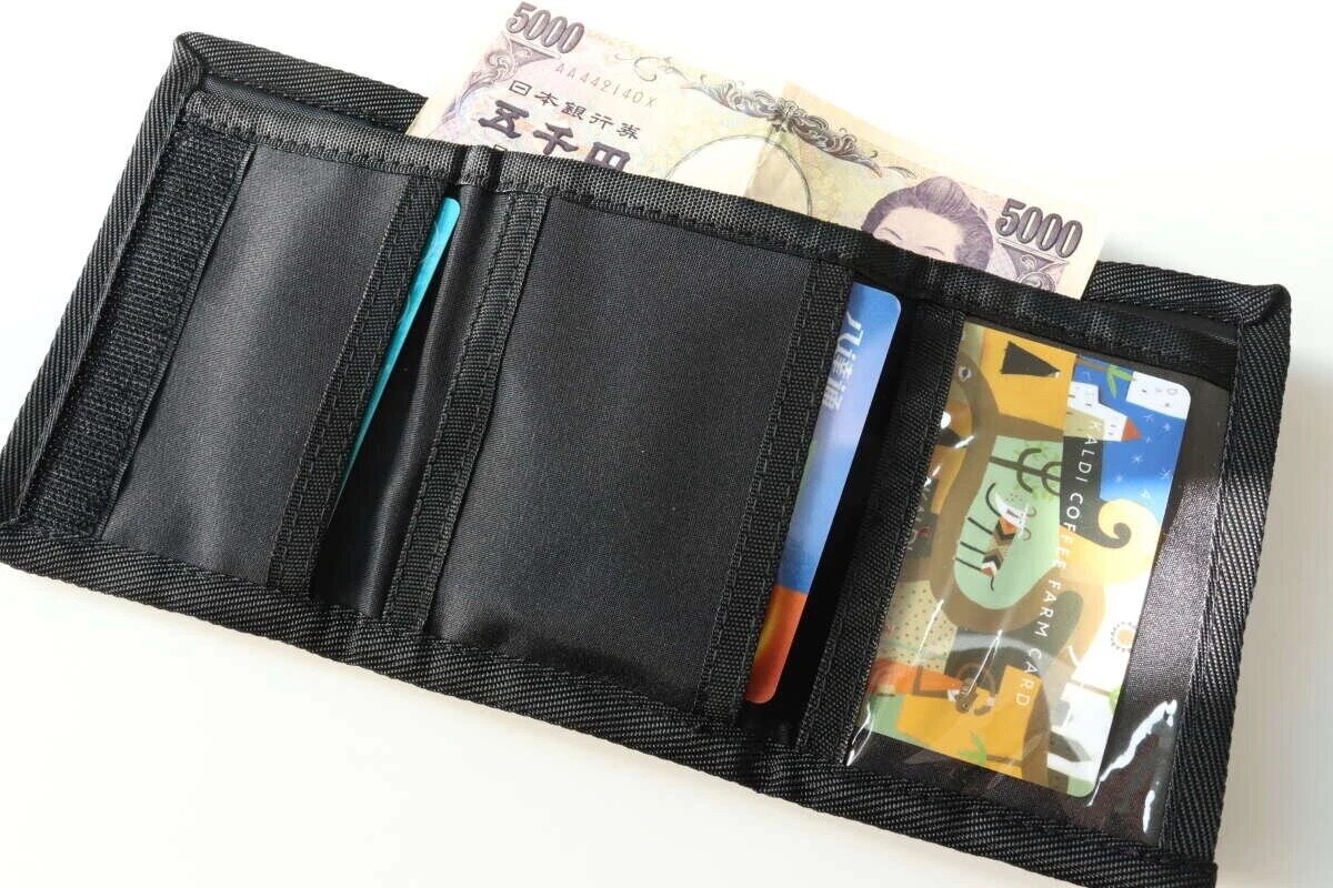 黒い紐付きキッズ三つ折りウォレットを開き、お札とカードが収納されている