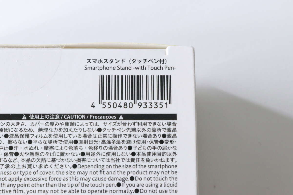 這是大創智慧型手機支架(附觸控筆)包裝背面條碼和警告標籤的特寫。 ダイソーのスマホスタンド(タッチペン付)のパッケージ裏面にあるバーコードと注意書きのアップ。