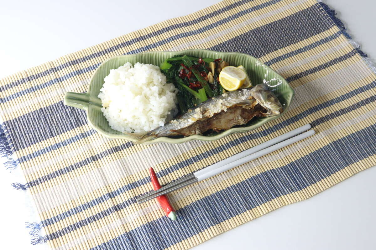 餐桌上擺放著日式料理,餐墊是竹製的。 竹ランチョンマットに和食が盛り付けられた食卓