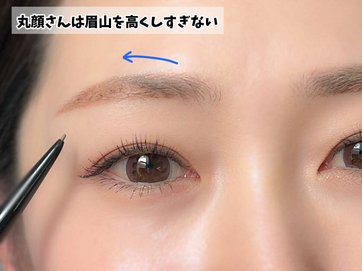 眉ペンシルで眉頭から眉山へ向かって眉を描いている女性の顔のアップ 眉ペンシルで眉頭から眉山へ向かって眉を描いている女性の顔のアップ