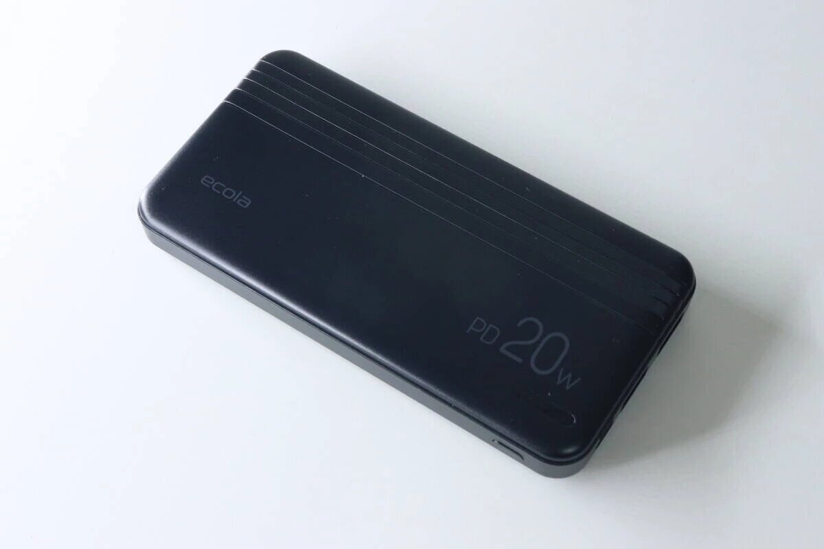從上方斜角拍攝的黑色移動電池照片。 “PD 20W”標誌清晰可見。 黒いモバイルバッテリー本体を斜め上から見た様子。「PD 20W」のロゴが見える