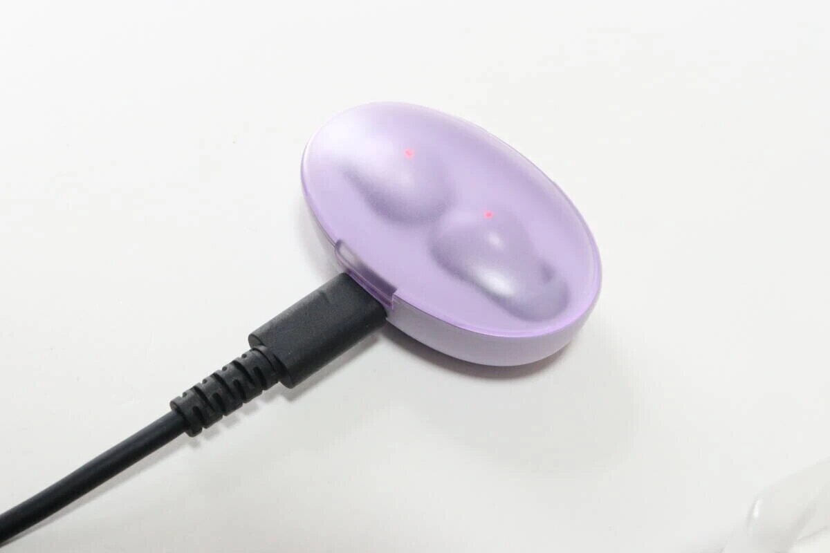 紫色無線耳機正在透過連接到充電盒的 USB Type-C 連接線進行充電。 紫色のワイヤレスイヤホン充電ケースにUSB Type-Cケーブルが接続され充電中