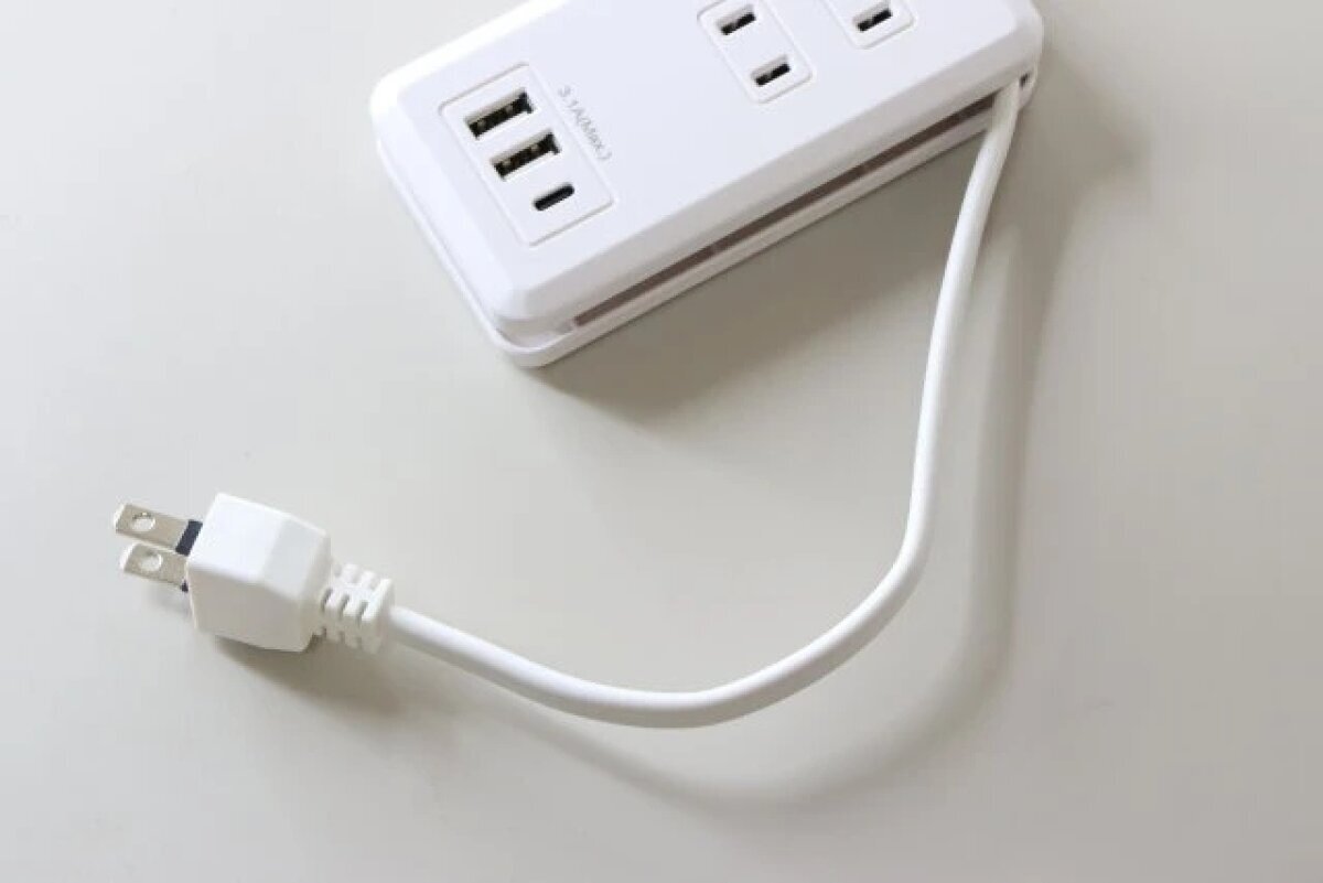 白色電源條的電源線纏繞在主體上,插頭則收納在內部。 白いコンセントタップの電源コードが本体に巻き付けられ、プラグが収納されている