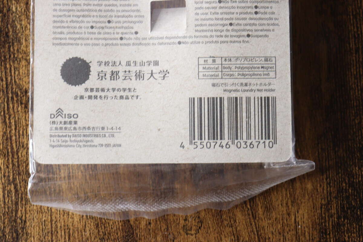 大創洗衣網架包裝背面的底部印有 JAN 代碼和京都藝術大學的標誌。 ダイソー洗濯ネットホルダーのパッケージ裏面下部、JANコードと京都芸術大学のロゴ