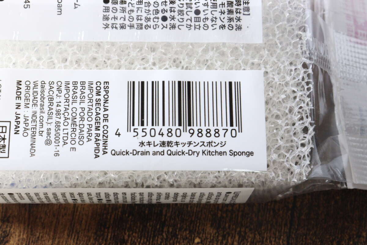 大創「速乾瀝水廚房海綿」包裝上的條碼和產品名稱特寫 ダイソー「水キレ速乾キッチンスポンジ」パッケージのバーコードと商品名部分のアップ