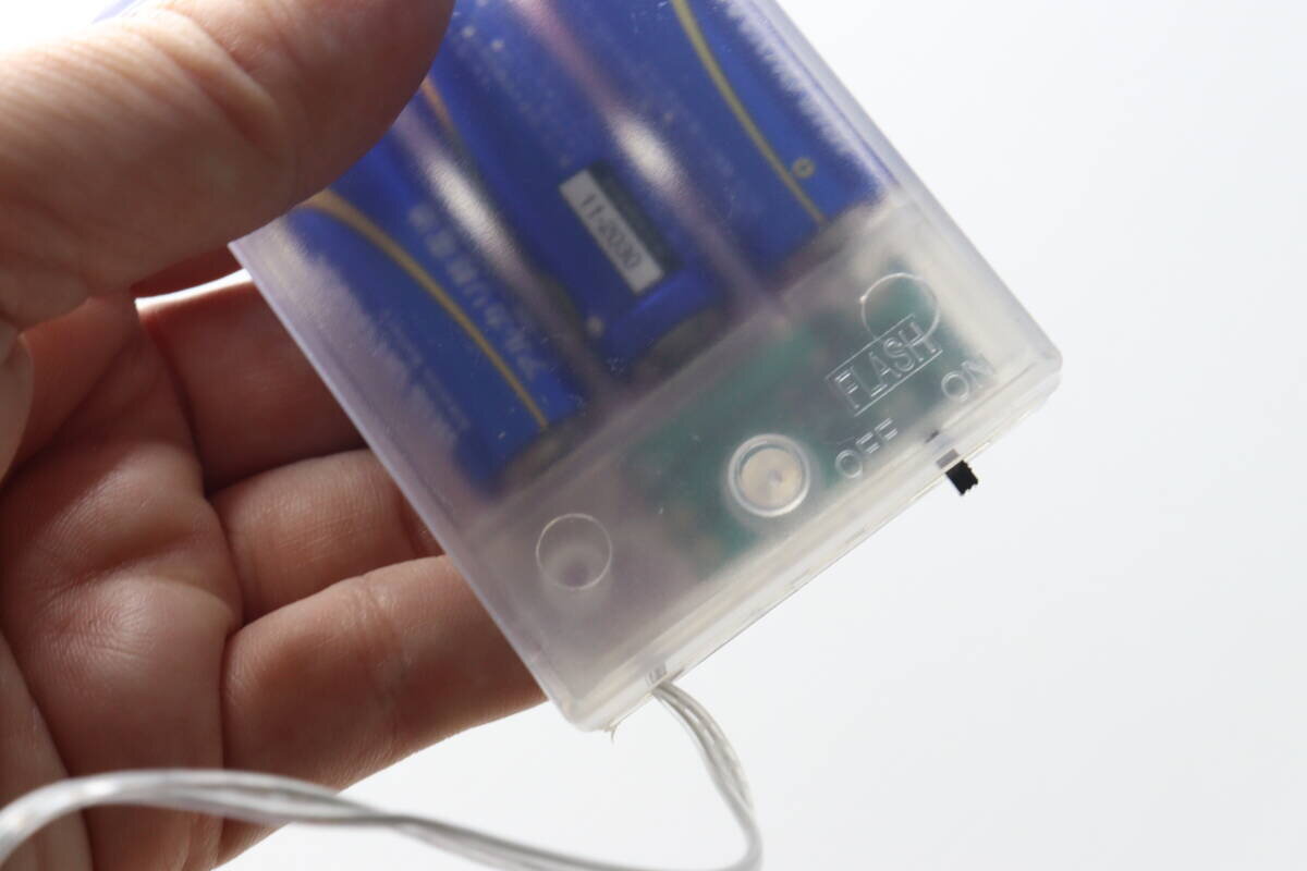 這是位於燈串電池盒上的開關,用於改變照明模式。 ストリングライトの電池ボックスにある、点灯モードを切り替えるスイッチ部分。
