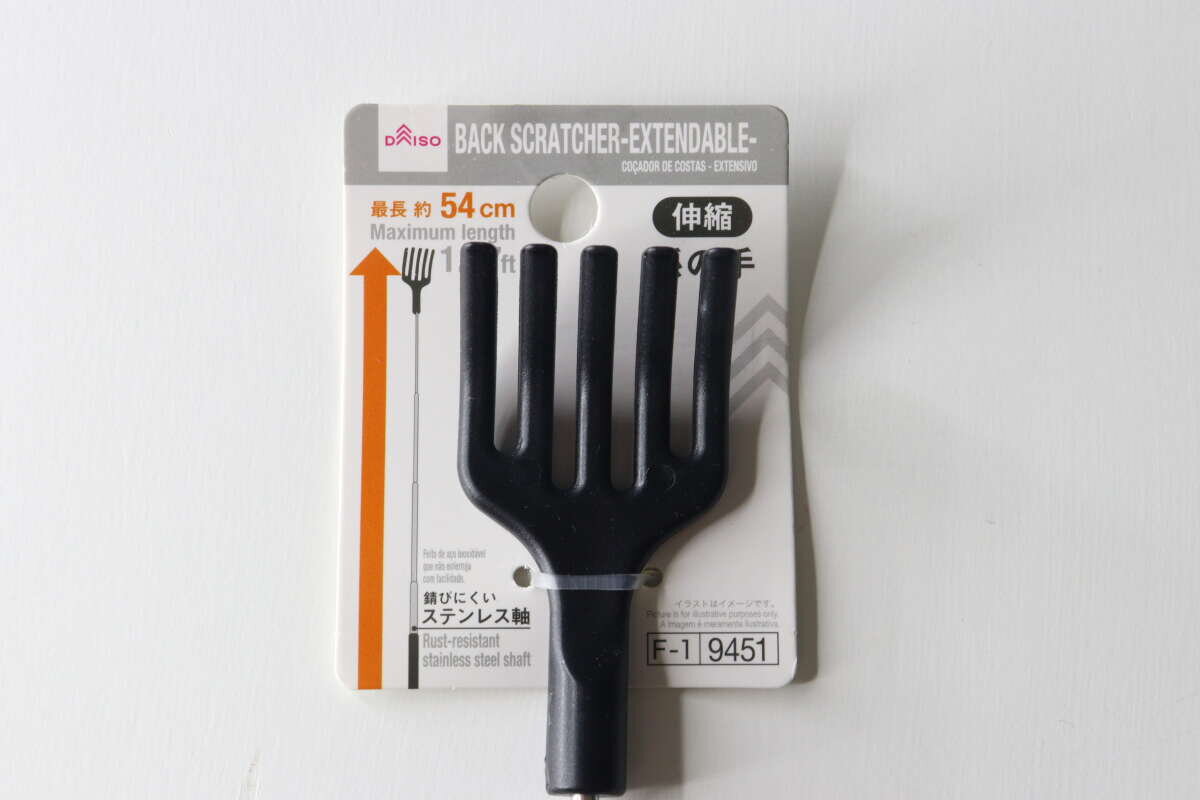 大創出品的背部按摩器黑色尖端的包裝和整體外觀。 ダイソーの孫の手のパッケージと黒い先端部分の全体像