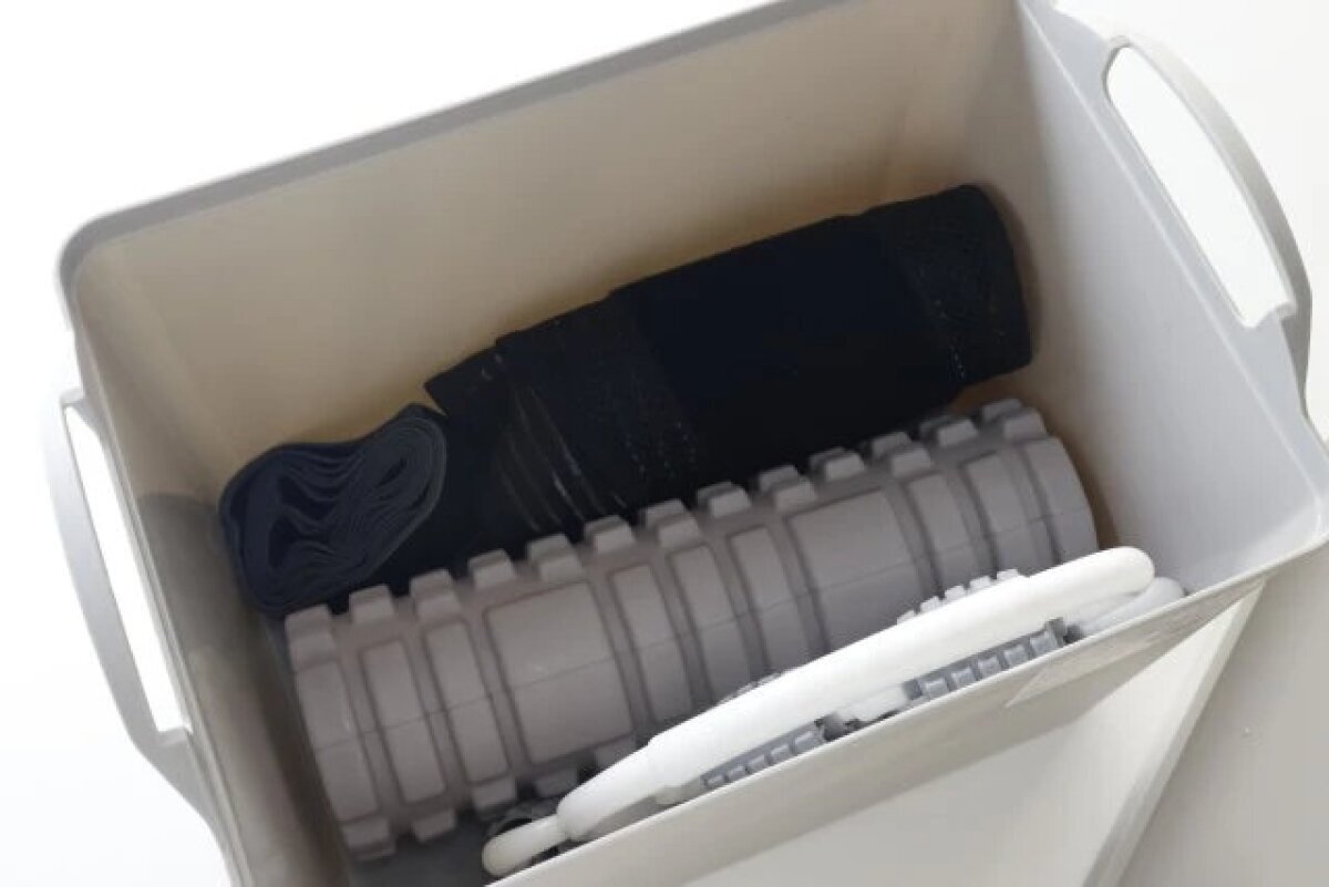 収納ボックスの中にフォームローラーやエクササイズ用品が収まっている様子