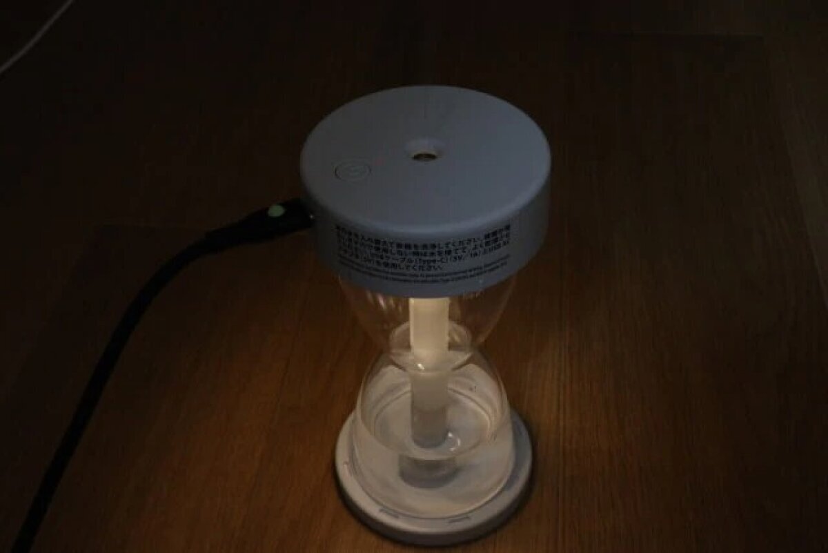 一款沙漏形加濕器,在黑暗的房間裡打開燈時會發出柔和的光芒。 暗い部屋でライトを点灯させ柔らかく光る砂時計型加湿器