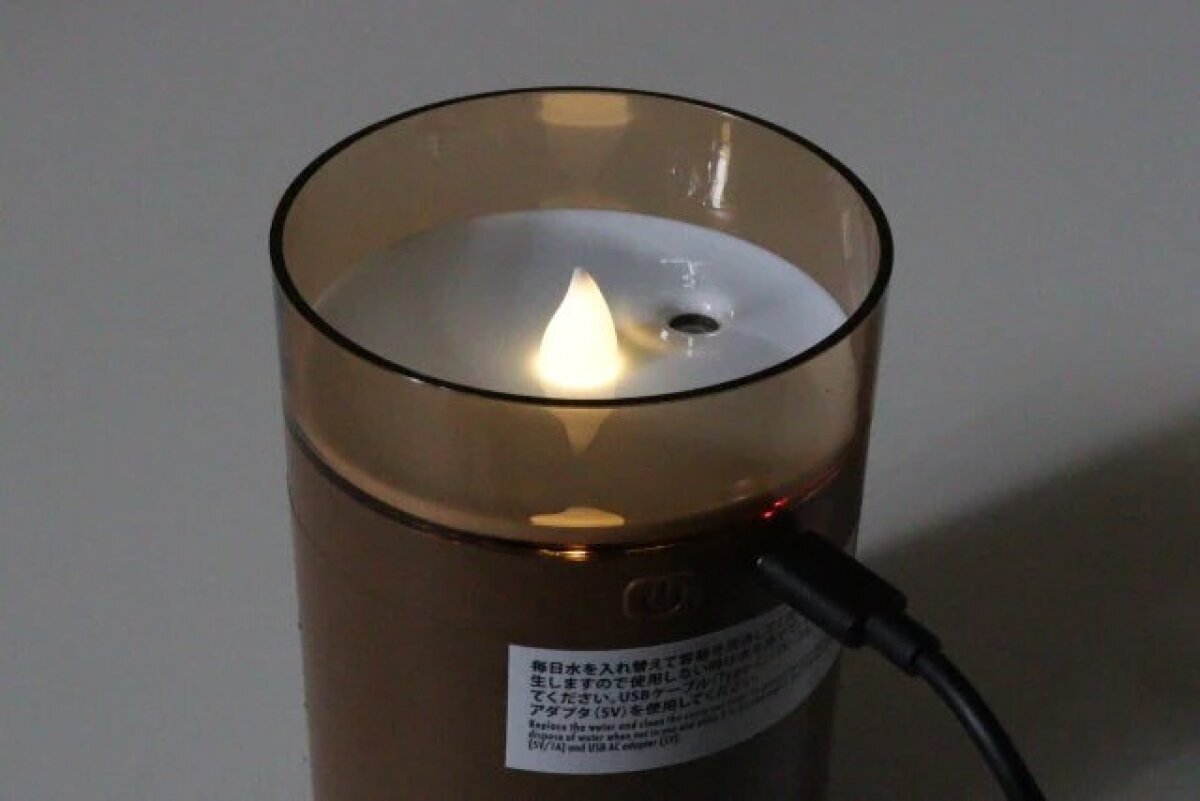 一款帶有火焰狀指示燈的加濕器,在黑暗的房間裡像蠟燭一樣發光。 暗い部屋で炎の形をしたライトがキャンドル風に光る加湿器