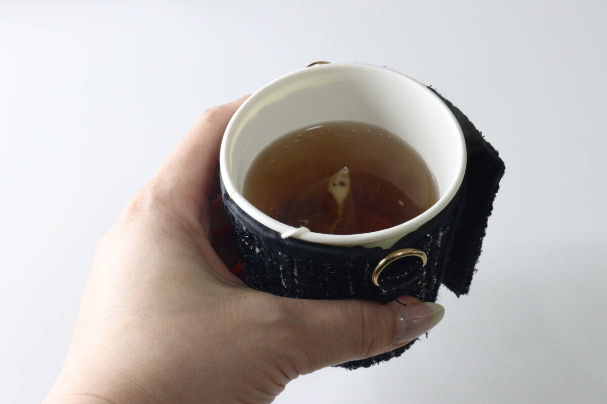 帶子已被取下,只剩下杯套,這個人手裡拿著杯子。 ストラップを外しスリーブのみにしてカップを手に持っている様子