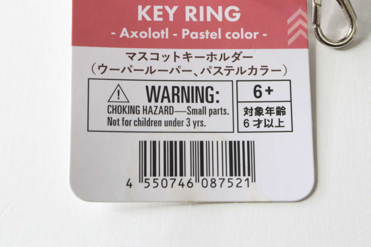 紙質標籤的特寫,顯示了吉祥物鑰匙圈的產品名稱和 JAN 代碼。 マスコットキーホルダーの商品名とJANコードが記載された紙タグのアップ