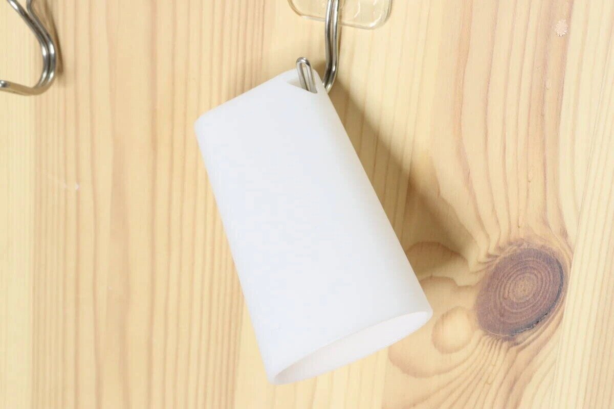 木製の壁に取り付けられたフックに白いスリムコップのフック穴を引っ掛けて干している状態