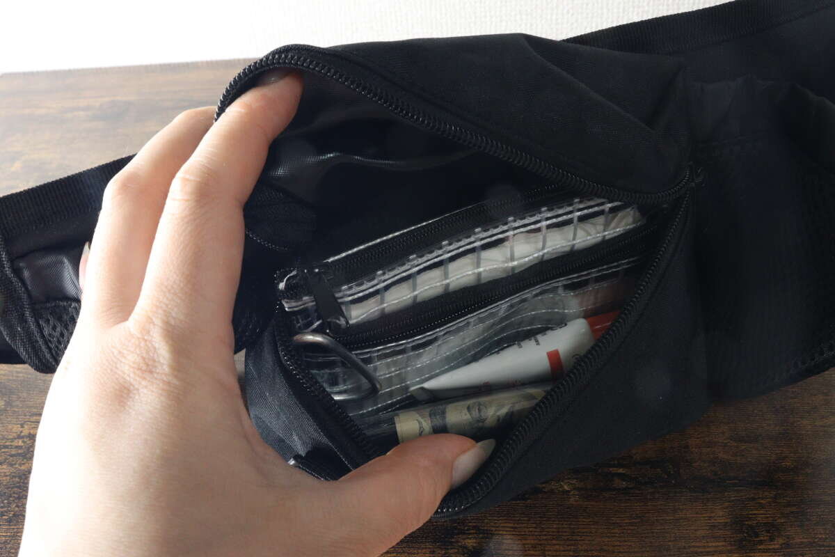 主拉鍊口袋用於存放小物。 メインのファスナーポケットに小物を収納している様子