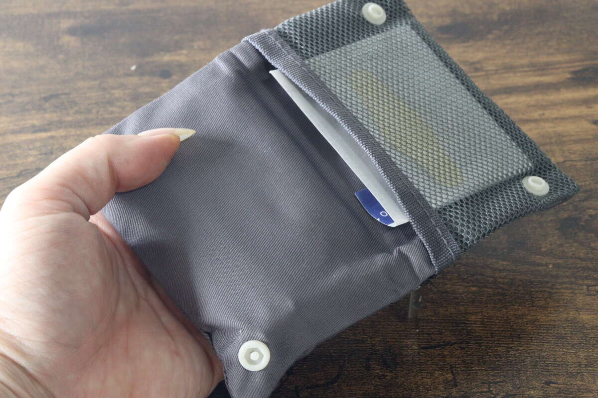 繃帶放置在一個帶有紐帶封口和可折疊結構的網狀口袋中。 ボタン付きの折りたたみ構造になったメッシュポケットに絆創膏を入れている状態