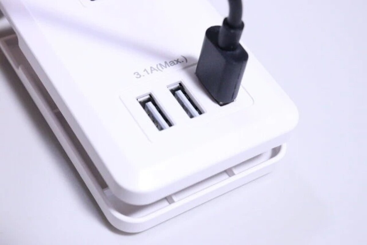 黑色電纜插入白色電源條的 USB 連接埠。 白いコンセントタップのUSBポート部分に黒いケーブルを挿している状態