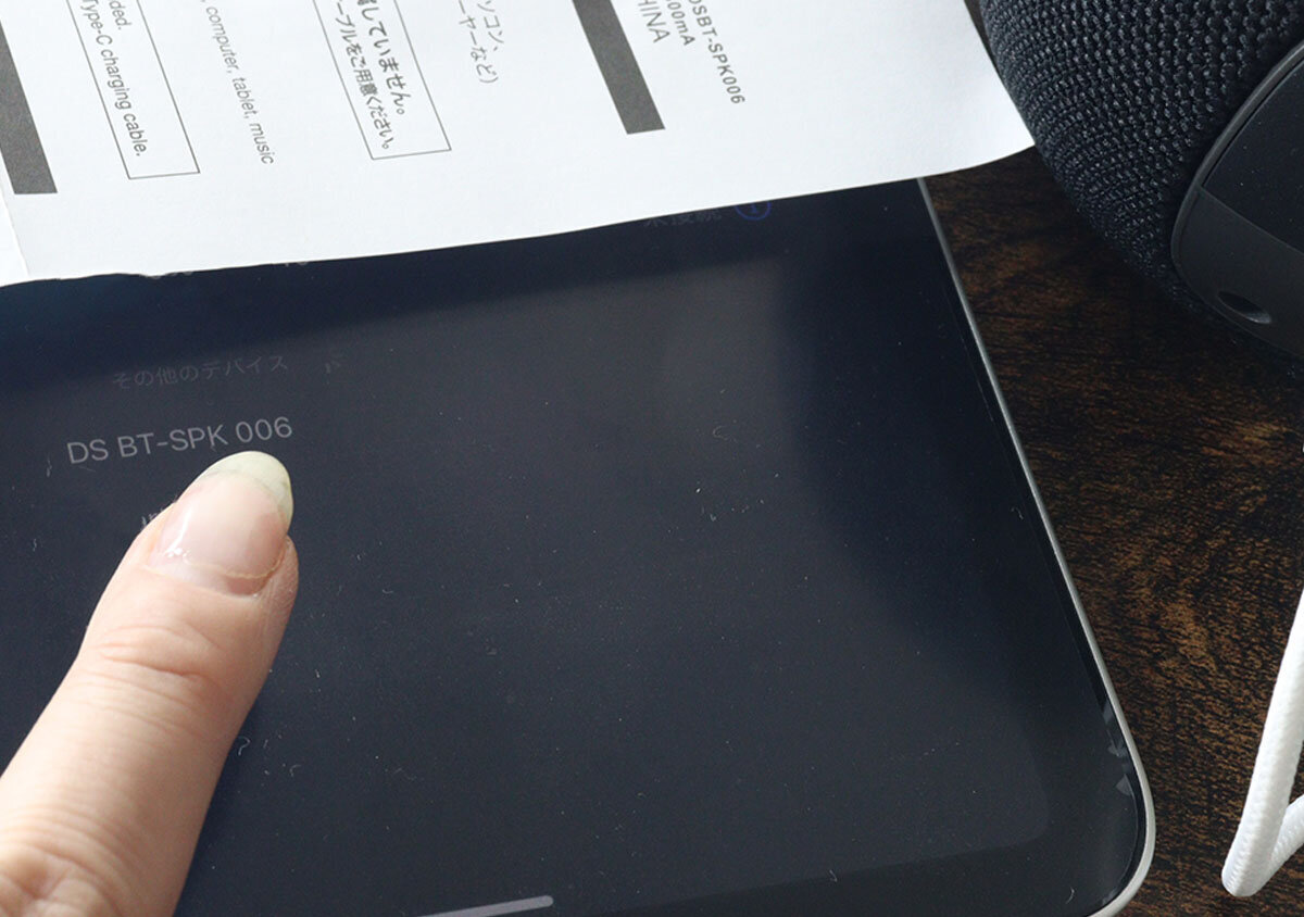 使用者正在點選平板電腦螢幕上顯示的裝置名稱。 タブレット端末の画面に表示されたデバイス名を指でタップしているところ