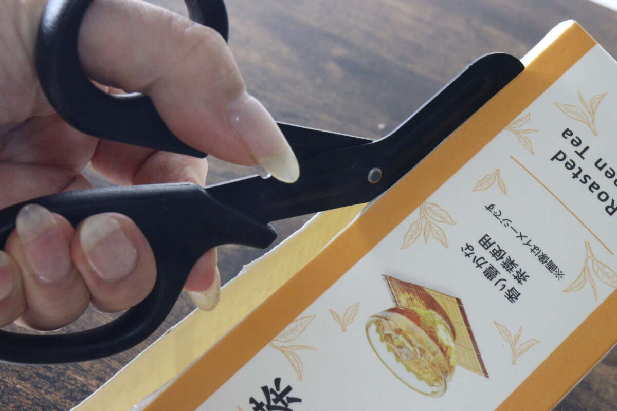 用裝有鋸齒刀片的廚房剪刀,將紙盒的側面平滑地剪開。 ギザ刃を備えたキッチンハサミで紙パックの側面をスムーズに切っている状態