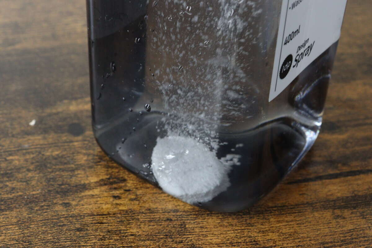 白色藥片在噴霧瓶的水中溶解並冒泡。 スプレーボトルに入れた水の中で白い錠剤が発泡しながら溶けている状態