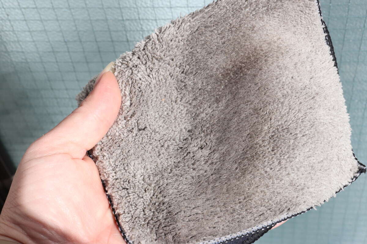 用來擦窗戶的灰色抹布沾滿了污垢。 窓掃除に使ったグレーのクロスに汚れがしっかりと付着している状態