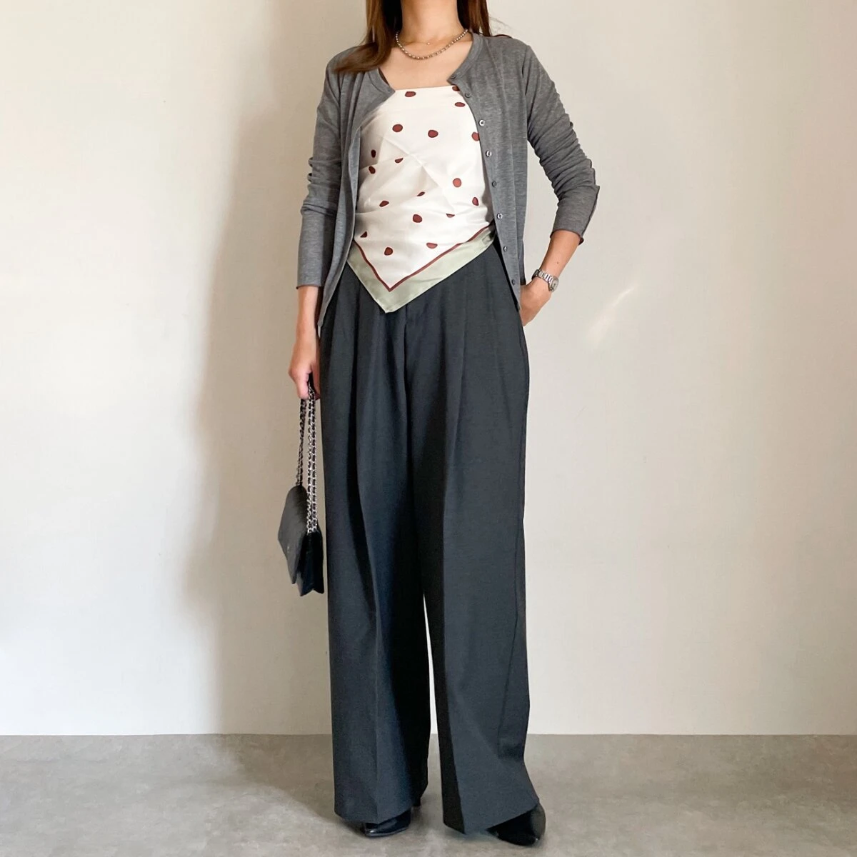 グレーカーデと黒ワイドパンツの女性がドット柄スカーフをベアトップ風に着る
