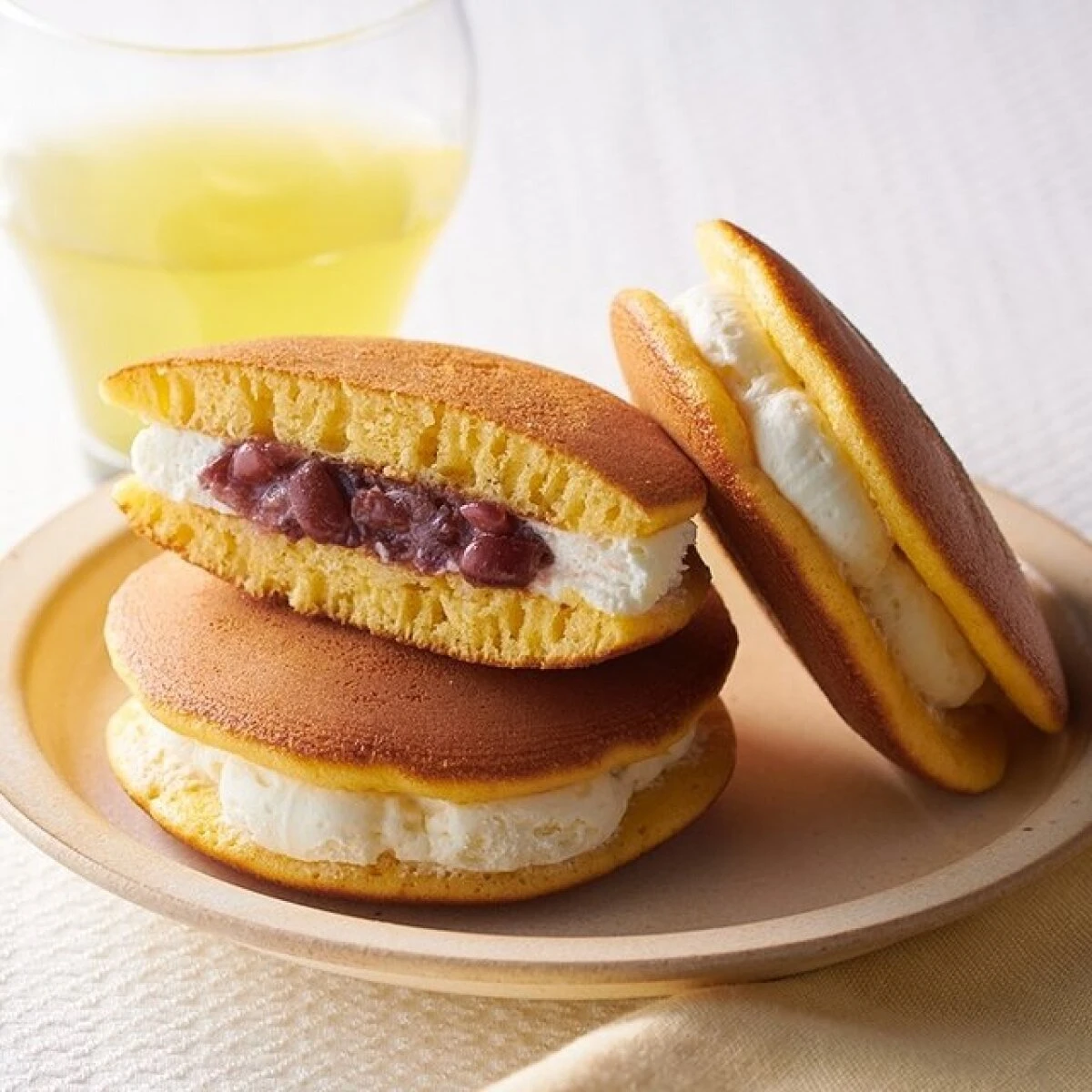 あんことクリームが挟まれたどら焼き2つとグラスに入った飲み物