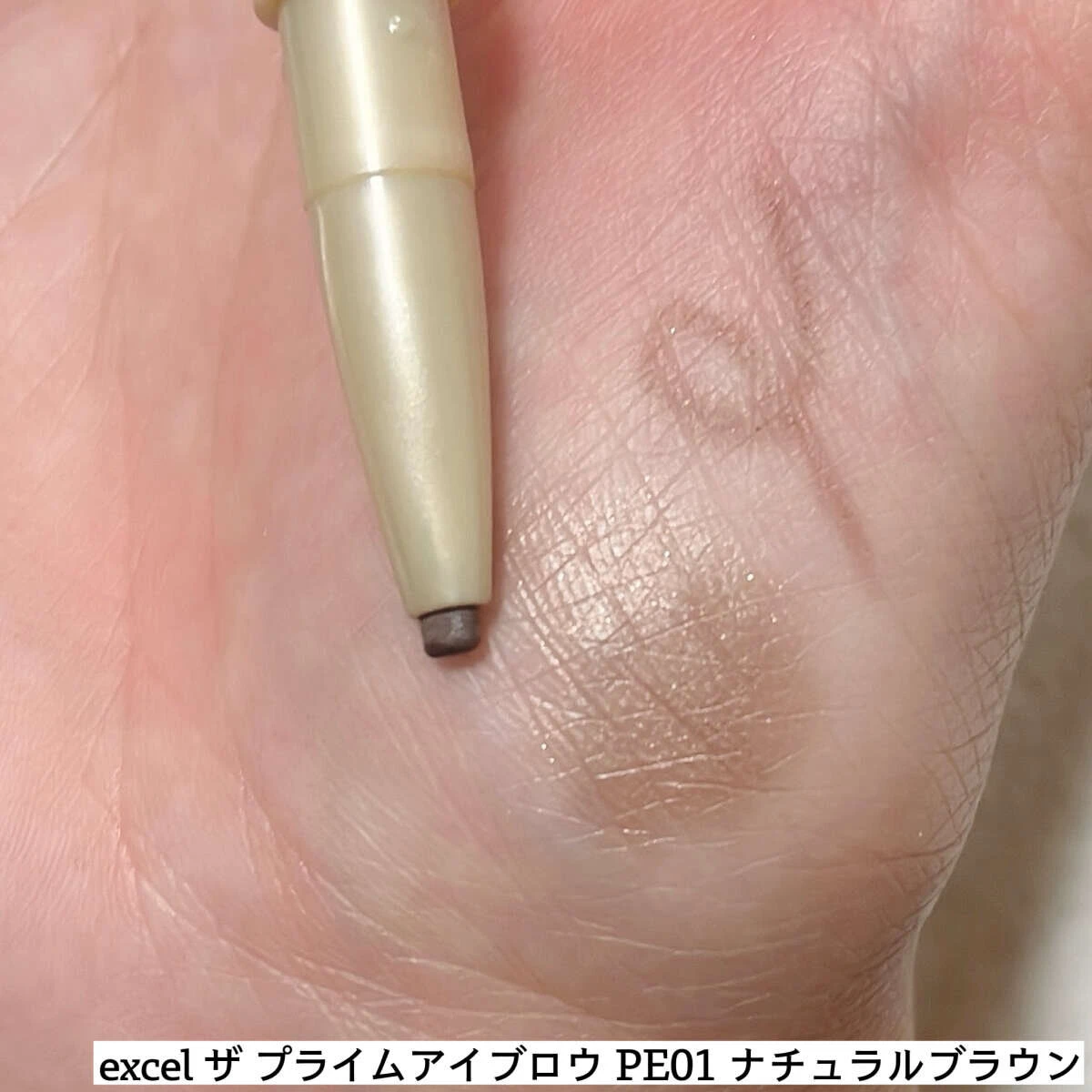 手の甲にエクセルのアイブロウペンシルで色を試している様子