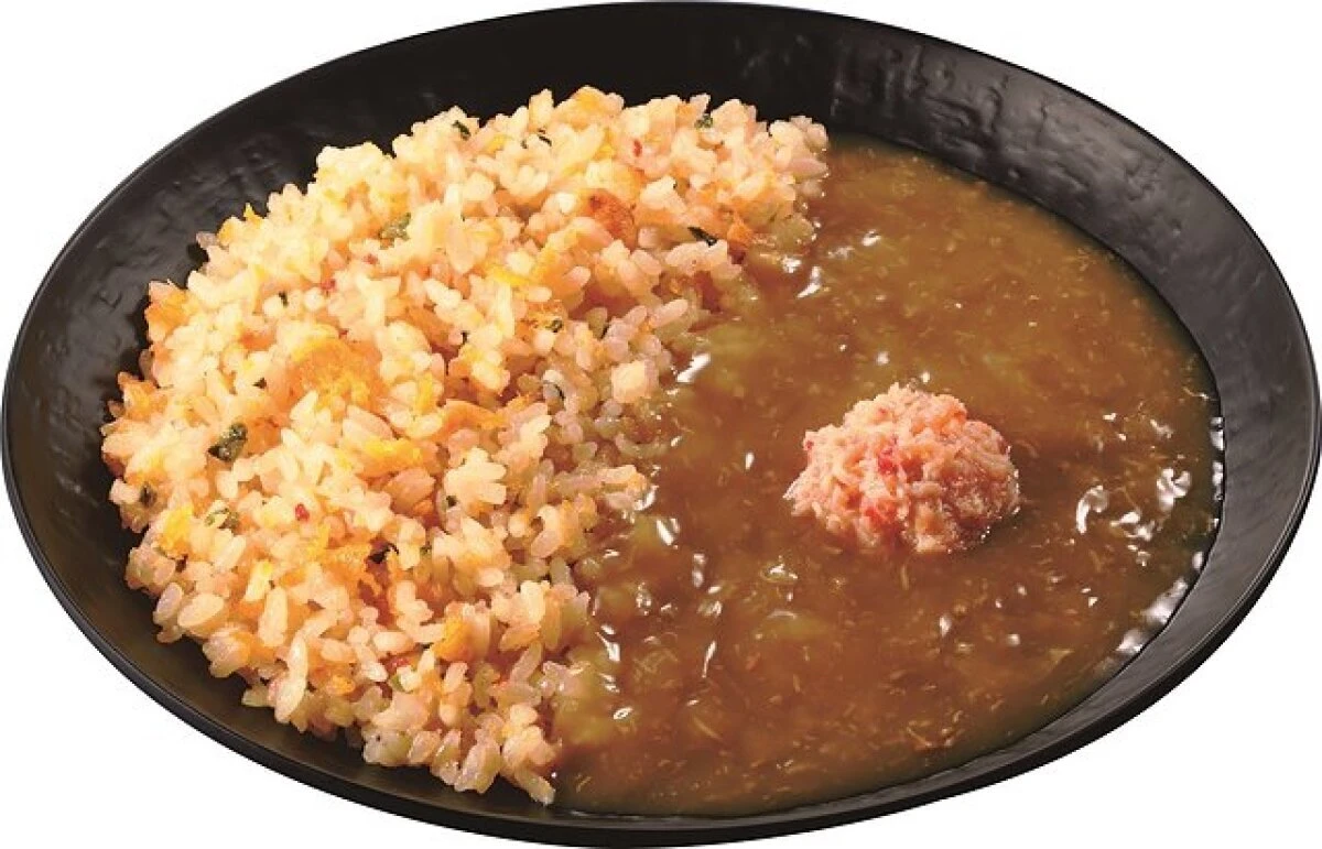 黒い皿に盛られたカニフレークが乗ったあんかけ炒飯