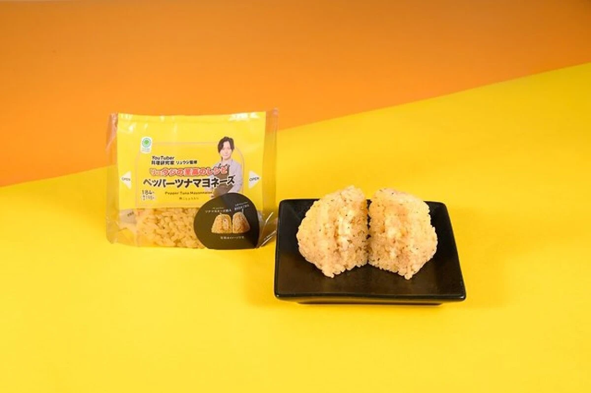 パッケージの横に半分にカットされたペッパーツナマヨネーズおむすびが置かれている様子 パッケージの横に半分にカットされたペッパーツナマヨネーズおむすびが置かれている様子