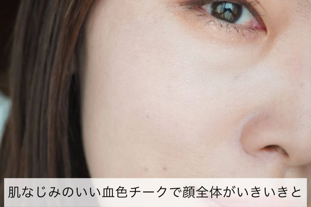 女性の顔のアップ。頬にピンク系のチークがほんのり塗られ、血色感がプラスされている。