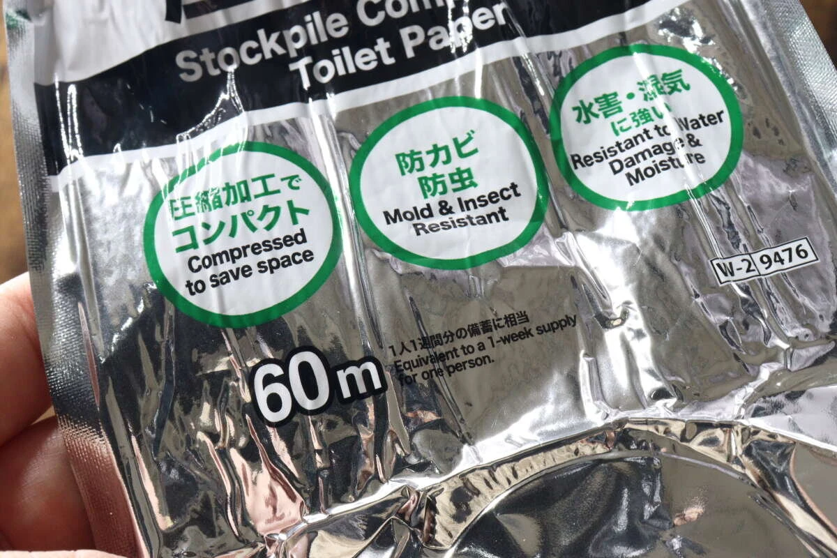 指で持たれたアルミ包装に書かれた「防カビ防虫」「水害・湿気に強い」などの説明文のクローズアップ。 指で持たれたアルミ包装に書かれた「防カビ防虫」「水害・湿気に強い」などの説明文のクローズアップ。