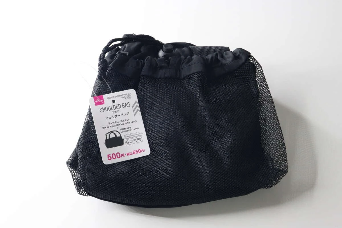 黒いメッシュ素材の巾着型バッグが畳まれ、商品タグが付いている様子
