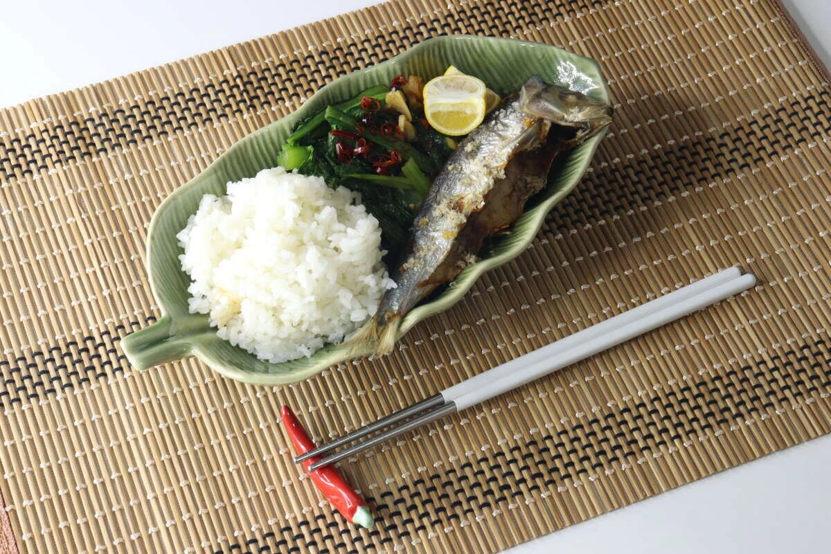 竹ランチョンマットの上に置かれた焼き魚とご飯の和食