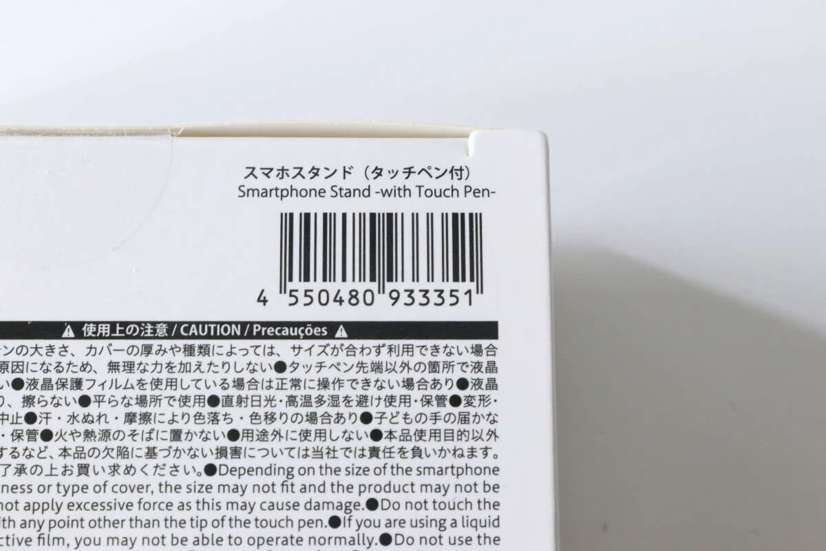ダイソーのスマホスタンド(タッチペン付)のパッケージ裏面にあるバーコードと注意書きのアップ。 ダイソーのスマホスタンド(タッチペン付)のパッケージ裏面にあるバーコードと注意書きのアップ。