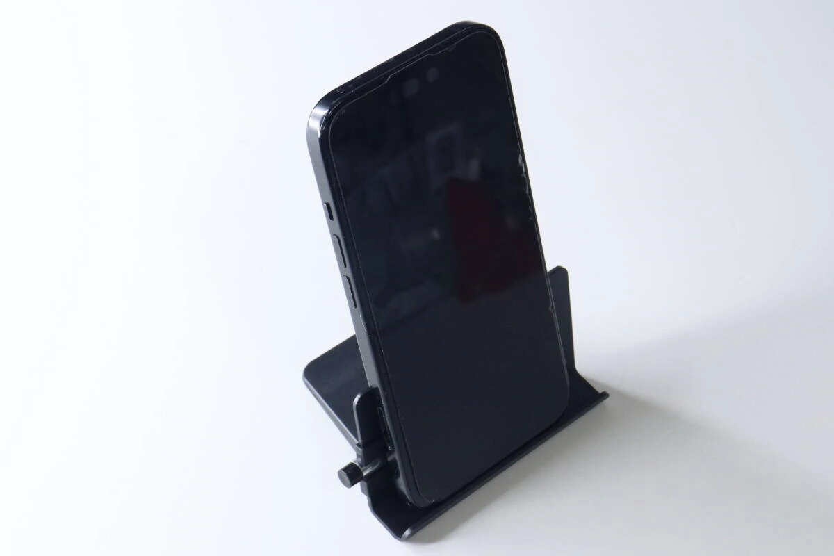 組み立てられた黒いスマホスタンドに、黒いスマートフォンが縦置きされている。 組み立てられた黒いスマホスタンドに、黒いスマートフォンが縦置きされている。