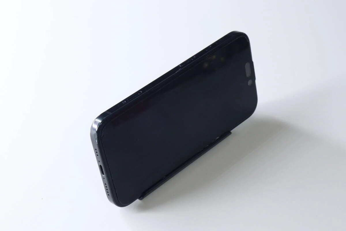 組み立てられた黒いスマホスタンドに、黒いスマートフォンが横置きされている。 組み立てられた黒いスマホスタンドに、黒いスマートフォンが横置きされている。