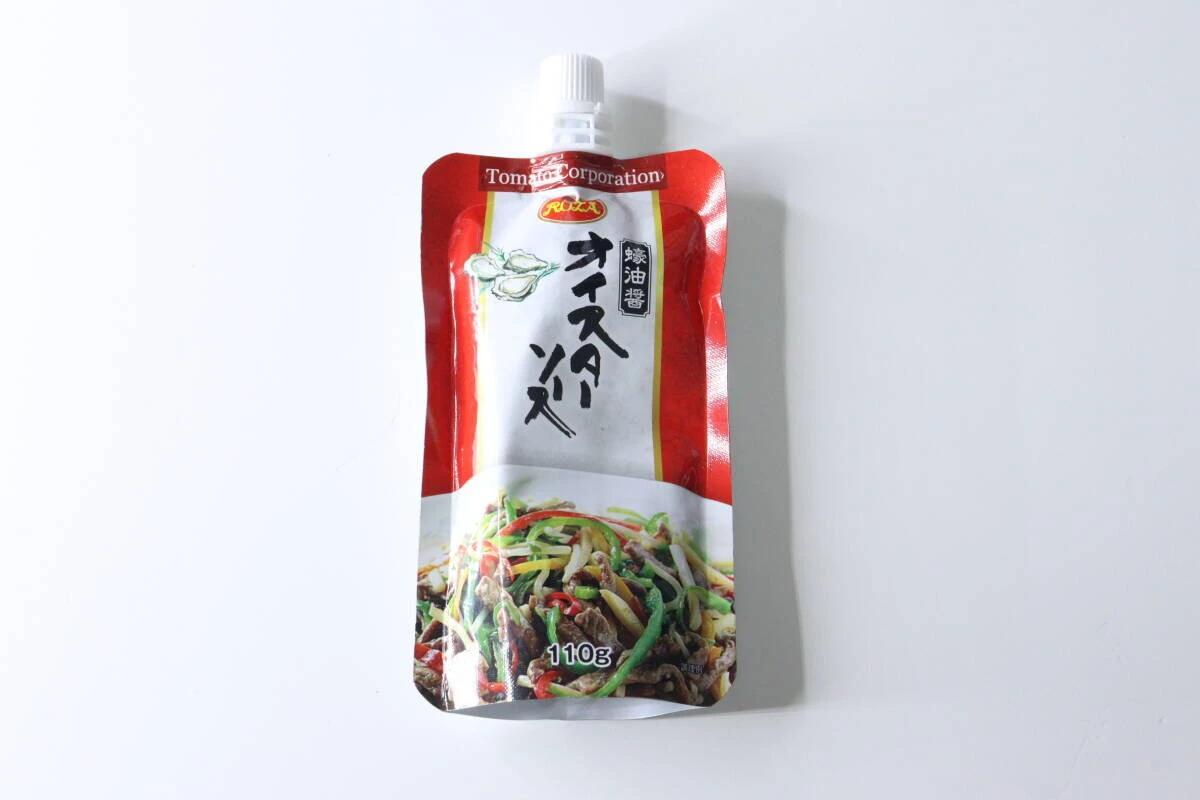 赤と白のパッケージのダイソーのパウチ型オイスターソースが白い背景に置かれている 赤と白のパッケージのダイソーのパウチ型オイスターソースが白い背景に置かれている