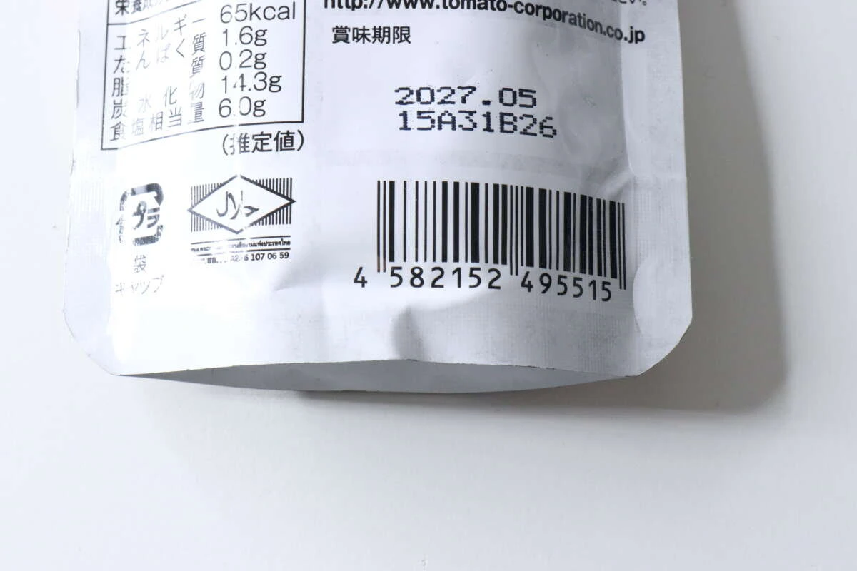ダイソーのオイスターソースのパウチ裏面に記載された賞味期限とバーコードのクローズアップ ダイソーのオイスターソースのパウチ裏面に記載された賞味期限とバーコードのクローズアップ