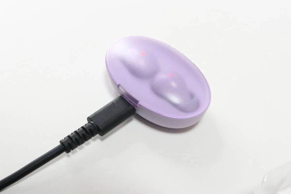 紫色のワイヤレスイヤホン充電ケースにUSB Type-Cケーブルが接続され充電中 紫色のワイヤレスイヤホン充電ケースにUSB Type-Cケーブルが接続され充電中