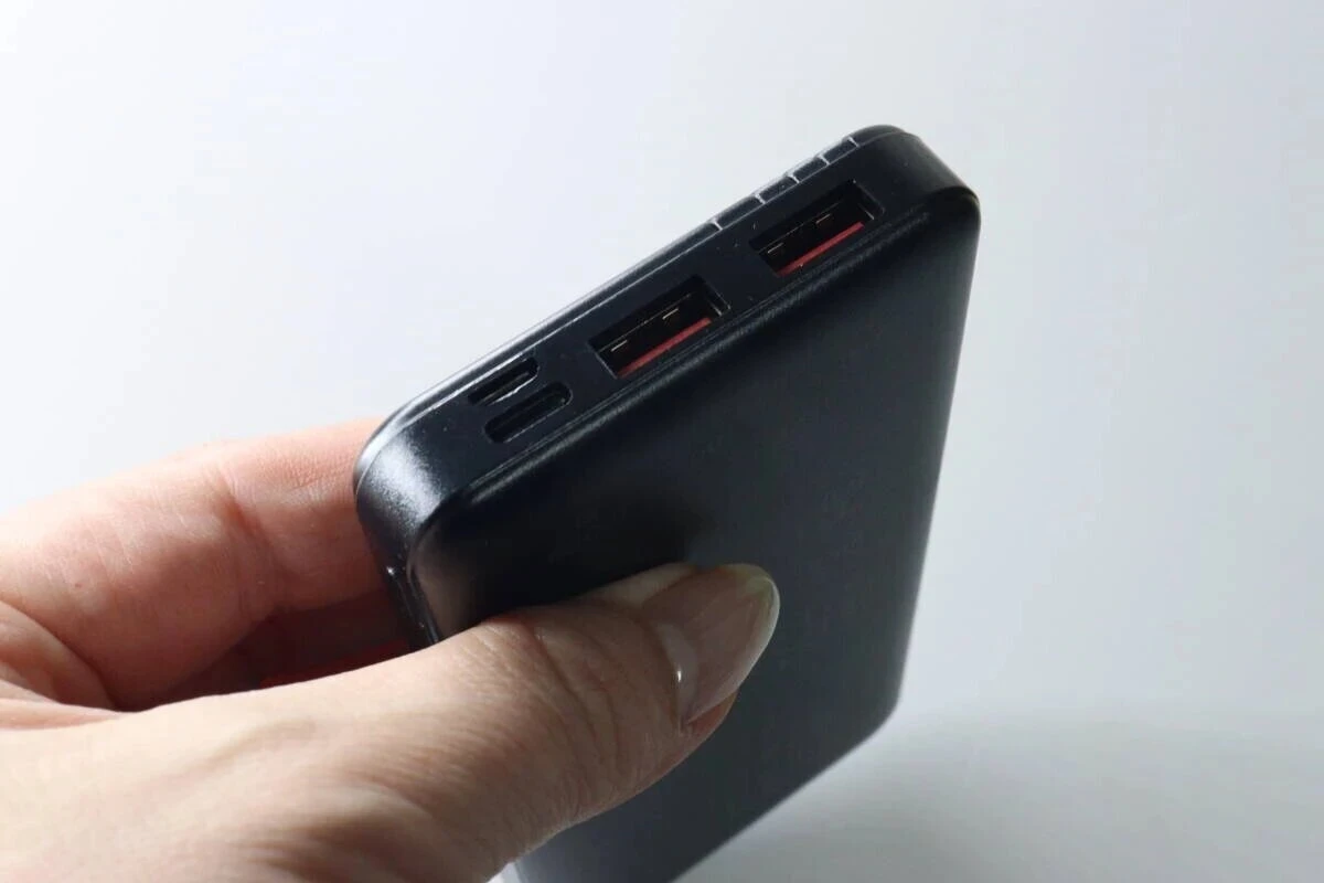 黒いモバイルバッテリーを片手で持っている様子。側面には複数の充電ポートがある 黒いモバイルバッテリーを片手で持っている様子。側面には複数の充電ポートがある