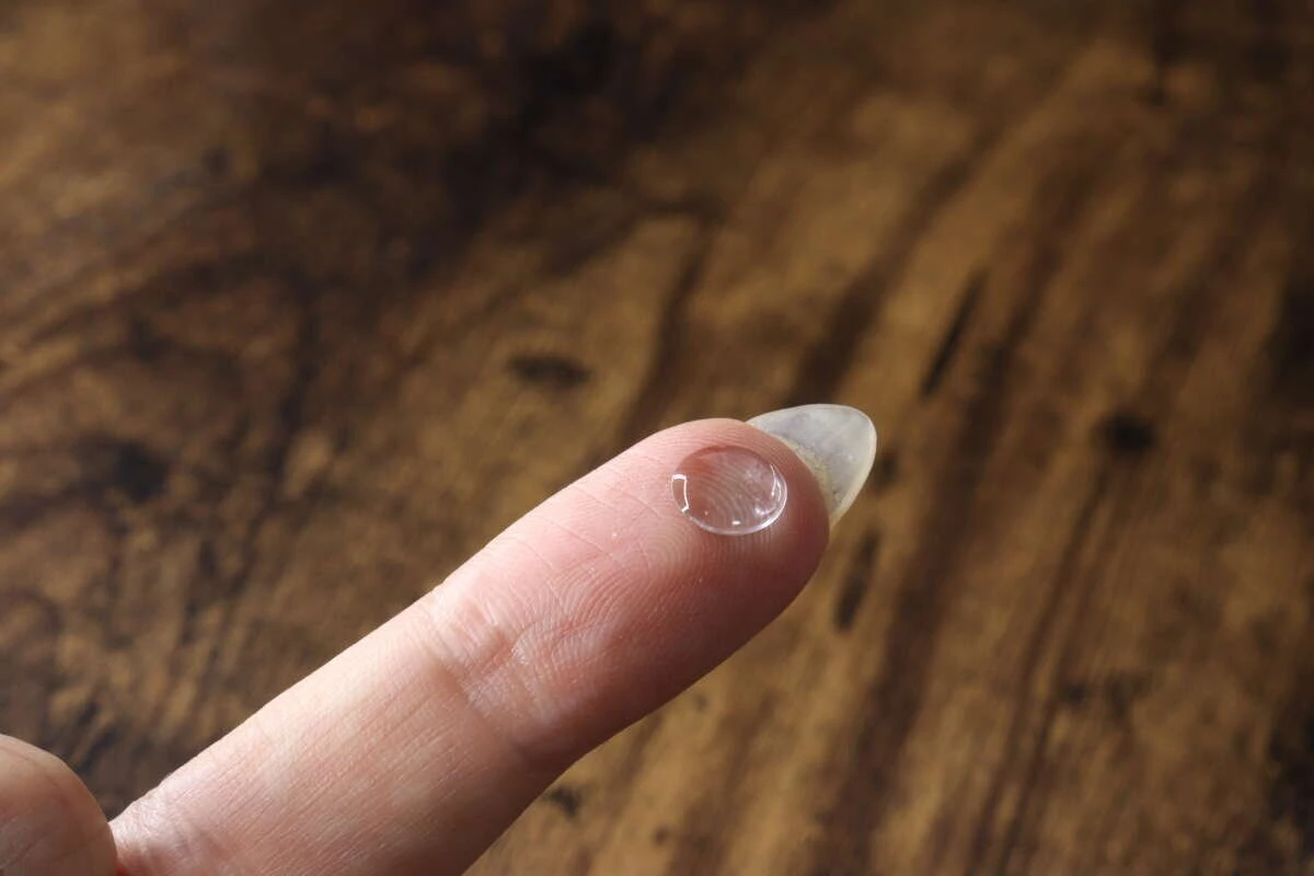 人差し指の先に貼られた透明でぷっくりしたポイントシール。
